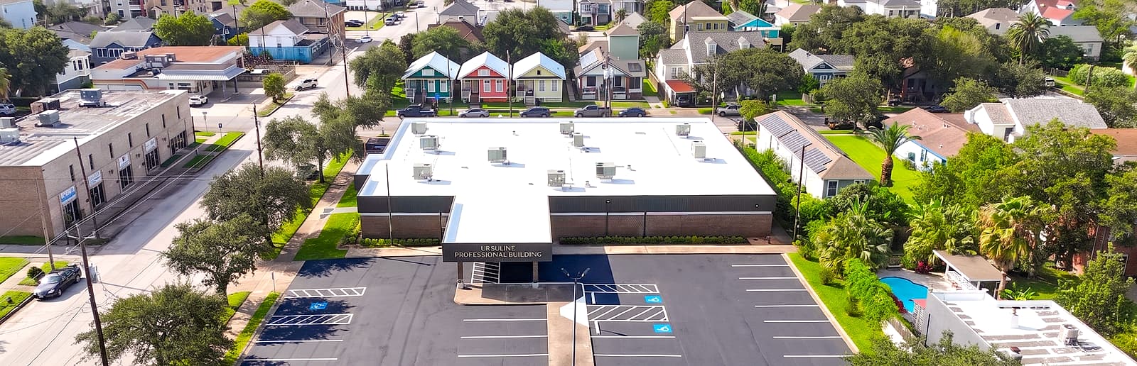 Aerial view of the Ursuline Professional Building, home of Magruder Family Dentistry, and the surrounding Galveston neighborhood